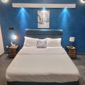 a bedroom with a large white bed with a blue wall at Hotel maty in Sali Tapé +53 photos