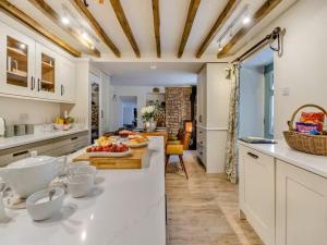 a kitchen with white counters and a table with fruit on it at Private lodge spa, sauna, hot tub, outdoor kitchen with firepit area in Shrewsbury