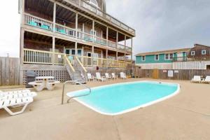 a large swimming pool in front of a building at 8 Bed Oceanfront in OBX with Pool & Hot Tub in Frisco
