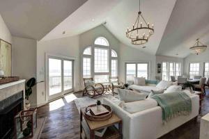a living room with a white couch and a fireplace at 8 Bed Oceanfront in OBX with Pool & Hot Tub in Frisco