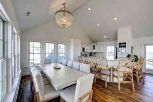a dining room and kitchen with a table and chairs at 8 Bed Oceanfront in OBX with Pool & Hot Tub in Frisco