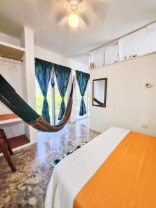 a room with a bed and a hammock in it at Villa Ixchel Tortugas in El Cuyo