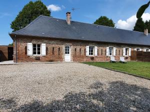 a brick house with a gravel driveway in front of it at La Bergerie in Saigneville