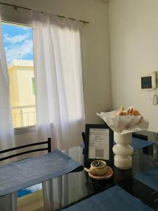 Una mesa de cristal con un jarrón sobre una mesa con ventana. en Alquileres Buendia 3, en Puerto Madryn