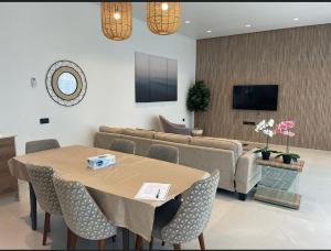 a living room with a table and a couch at Acacia Beach Villa in Al Sharqiyah