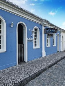 a blue building with a sign on the side of it at Hotel Estalagem Porto Seguro in Porto Seguro