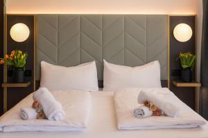 two stuffed teddy bears in towels on a bed at Florum Hotel in Vienna