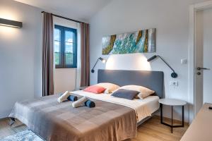 a bedroom with a bed with two stuffed animals on it at Villa Paronich in Barban +49 photos