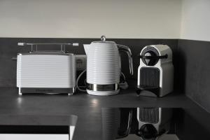a kitchen counter with several appliances on a shelf at ZUHAUSE AM MEER mit Sonnenbalkon in Strand- und Altstadtnähe in Warnemünde