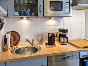 a kitchen counter with a sink and a coffee maker at Comfortable holiday home in nature in Schönberg +7 photos