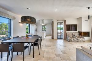 a dining room and living room with a table and chairs at Villa Paronich in Barban
