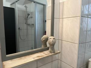 a mirror and a statue on a shelf in a bathroom at Appartement 5 Predigergasse in Bautzen