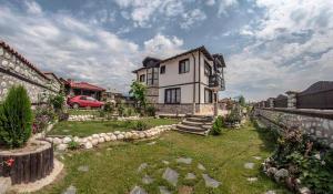 a large house with a yard in front of it at Guest House Tommy Bansko - Bachevo in Bachevo