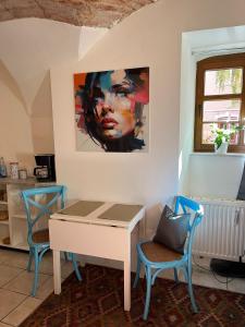 a table and chairs in a room with a painting on the wall at Appartement 5 Predigergasse in Bautzen +6 photos