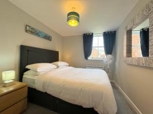 a bedroom with a bed with white sheets and pillows at The Warehouse Apartments, 1 - Bed, Sleeps 2, Ulverston - UK in Ulverston
