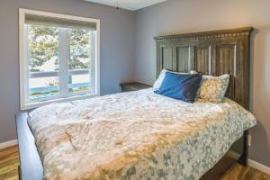 a bedroom with a bed with a wooden headboard and two windows at Lakefront Arkansas Escape with Grill, Dock and Kayaks! in Horseshoe Bend +6 photos
