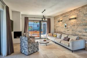 a living room with a couch and a brick wall at Villa Paronich in Barban