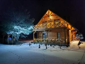 a log cabin in the snow at night at Chata Sosenka in Sygontka