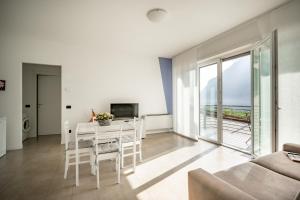 a living room with a white table and chairs at Lake Como Casa la Rosa wonderful view in Abbadia Lariana