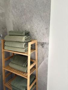 a pile of towels on a wooden shelf in a bathroom at Cityperle - im Herzen Augsburgs in Augsburg