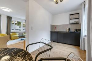 a kitchen and living room with a table and chairs at Cityperle - im Herzen Augsburgs in Augsburg +18 photos