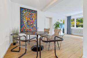 a room with a table and chairs and a painting at Cityperle - im Herzen Augsburgs in Augsburg