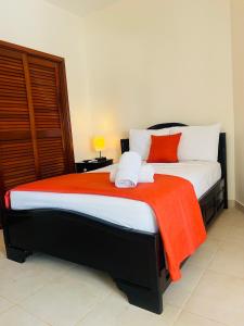una camera da letto con un grande letto con una coperta arancione di Hotelito del Mar - Main Street a Bocas del Toro