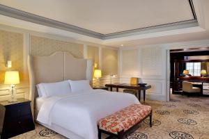 a bedroom with a large white bed and a piano at The Westin Dubai Mina Seyahi Beach Resort and Waterpark in Dubai