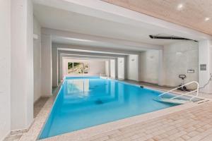 une grande piscine avec de l'eau bleue dans un immeuble dans l'établissement book2stay - Kuscheliges Alpin-Studio mit Schwimmbad, à Arosa