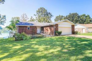 a brick house with a grass yard at Lakefront Arkansas Escape with Grill, Dock and Kayaks! in Horseshoe Bend