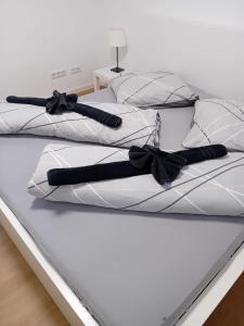 a white bed with black bows on it at ~Ferienwohnung Sandhausen / HD~ in Sandhausen