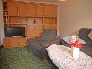 Ferienhäuser am Teich, Zinnowitz في زينوويتز: غرفة معيشة مع كرسيين وتلفزيون بشاشة مسطحة