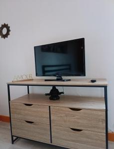 a flat screen tv sitting on top of a wooden dresser at Ma retraite spirituelle - curistes - à 2mn des Thermes et 45 mn de l'Espagne in Amélie-les-Bains-Palalda