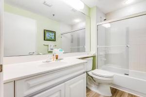 a bathroom with a sink and a toilet and a shower at Beach Colony East Navarre 3A in Navarre +17 photos