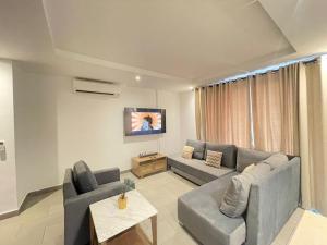 阿克拉Luxury Labone Edge 2-bedroom apartment in Accra - FiveHills homes的带沙发和电视的客厅