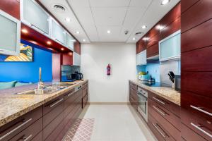 a kitchen with wooden cabinets and a sink at Burj Khalifa & Fountain View- 5mn walk to Dubai mall -Stylish 1BDR Apartment in Dubai +44 photos