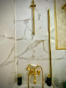 a sink with a gold faucet and a cross on a wall at El Balcón de Fuenteheridos in Fuenteheridos