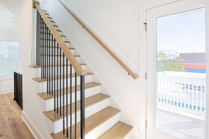 a staircase in a house with a glass door at Luxury New Build with Oceanview - Go with the Flo 1 in Carolina Beach +46 photos