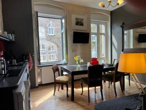 Una cocina y un comedor con mesa y sillas. en Vis-a-vis Apartments, en Traben-Trarbach