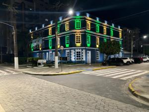 a building with green lights on the side of it at AP 50 Metros do Mar in Mongaguá