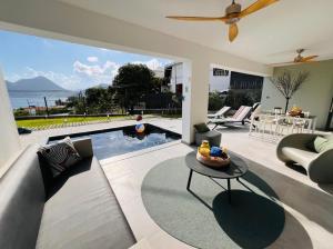 ein Wohnzimmer mit einem Pool und einem Tisch in der Unterkunft Le BÔ Diamant Garden - appartement standing avec jardin, piscine et vue mer in Le Diamant