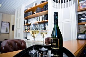 - une bouteille de vin et deux verres sur une table dans l'établissement Champagne André Bergère, à Épernay