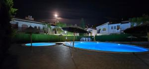 a swimming pool with two umbrellas at night at Green Oasis in Gran Alacant