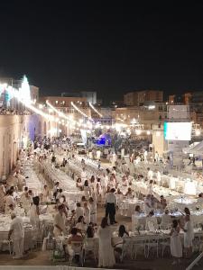 a crowd of people sitting at tables at night at Anna Luxury Apartment in Bisceglie