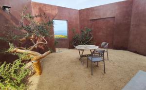 a patio with a table and chairs and a tree at Estudio Nacui in El Sargento