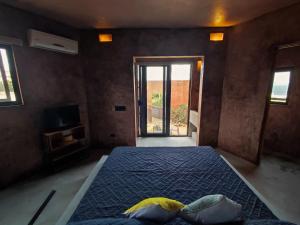 a bedroom with a bed and a tv and a window at Estudio Nacui in El Sargento