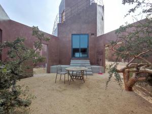 a patio with a table and chairs in front of a building at Estudio Nacui in El Sargento