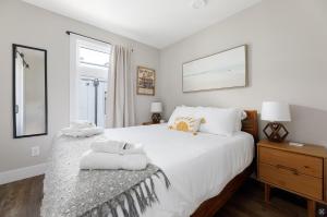 a bedroom with a large white bed with towels on it at The Suncatcher on Gillis in Traverse City
