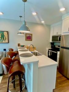 a kitchen with a white counter and some brown chairs at The Suncatcher on Gillis in Traverse City +11 photos