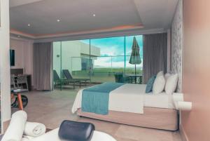 a bedroom with a large bed and a large window at Paradiso Peró Praia Hotel in Cabo Frio +102 photos